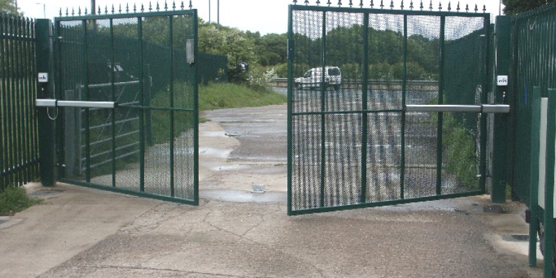 Large industrial steel gate painted in green colour which is operates automatically when the vehicles comes in or goes out.