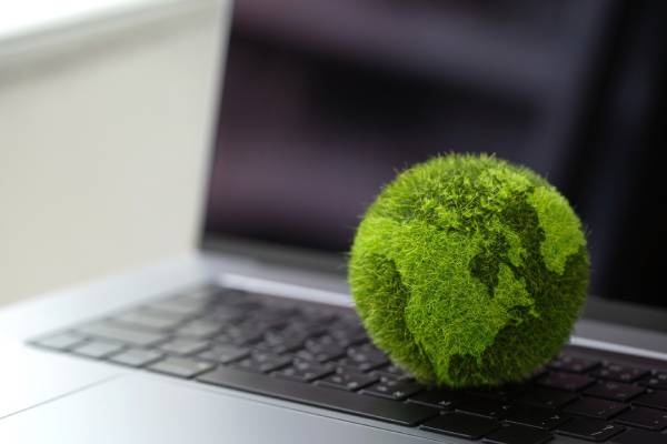 Laptop keyboard with Green Globe on it showing carbon efficient technology. 